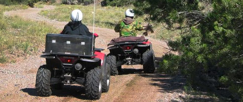 2 people riding ATVs