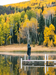 A woman on a pier admires the fall aspen colors at Pearl Lake State Park.