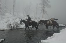 Man on horseback with pack horse in winter. Photo by Bailey Franklin.