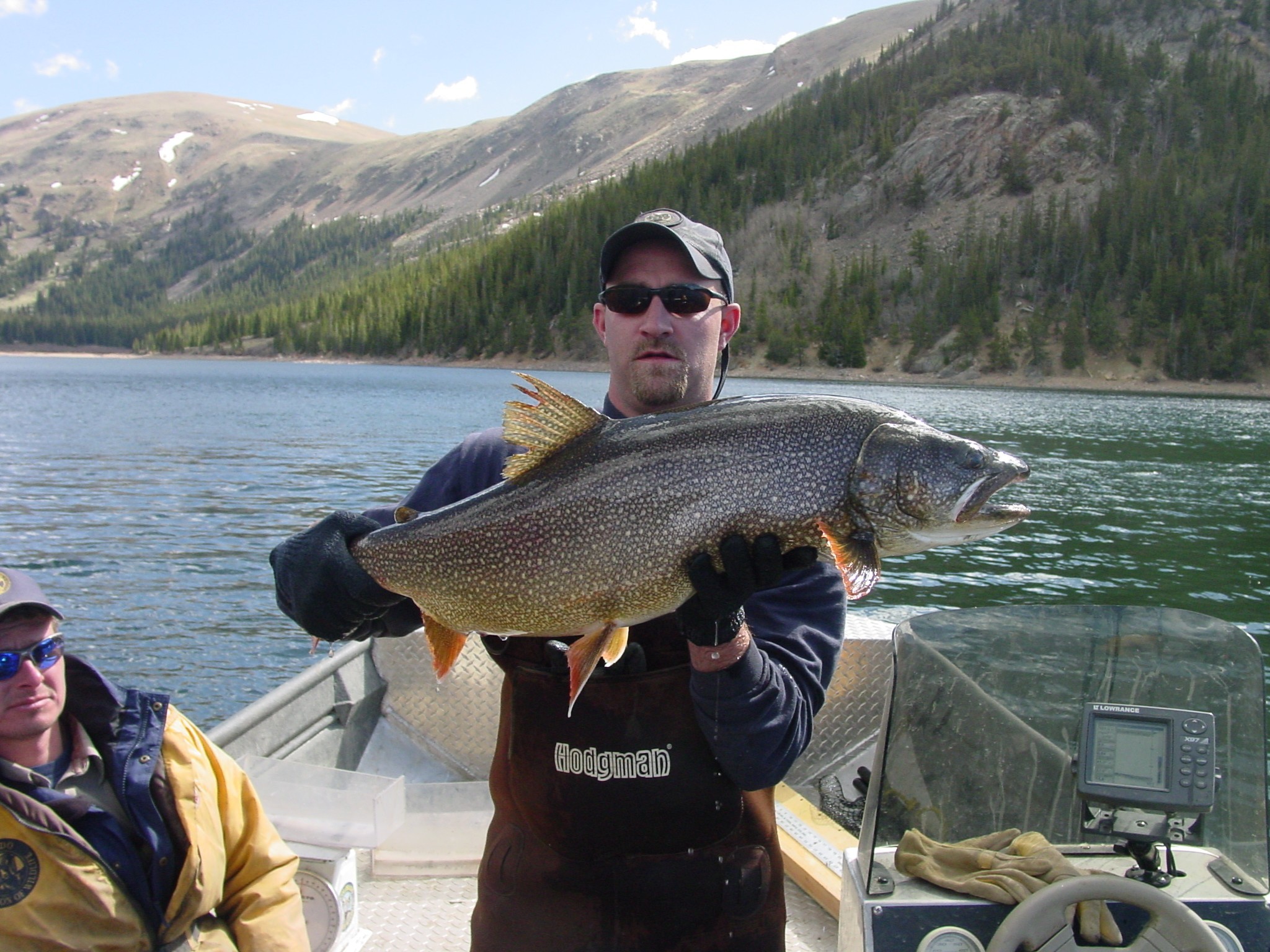 CPW wildlife biologist with a lake trout on Jefferson Lake.