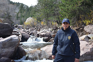 Female park ranger on location next to waterfall