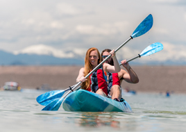 Woman and man paddling a kayak.