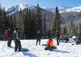 People practice winter search and rescue skills.