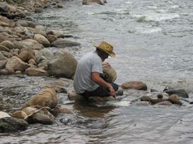 Man crouching in river Gold Prospecting at Point Barr