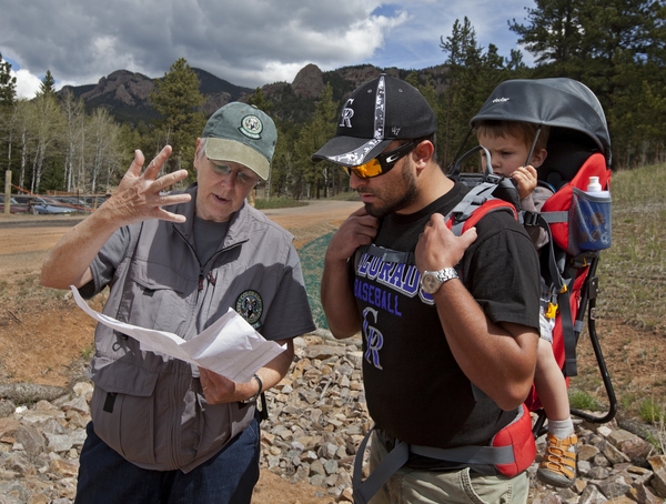 Park volunteer showing father/son a map