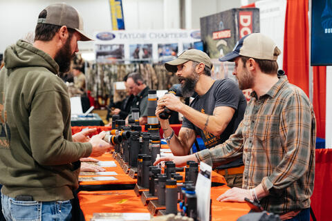 Expo visitors talk with binoculars sellers.