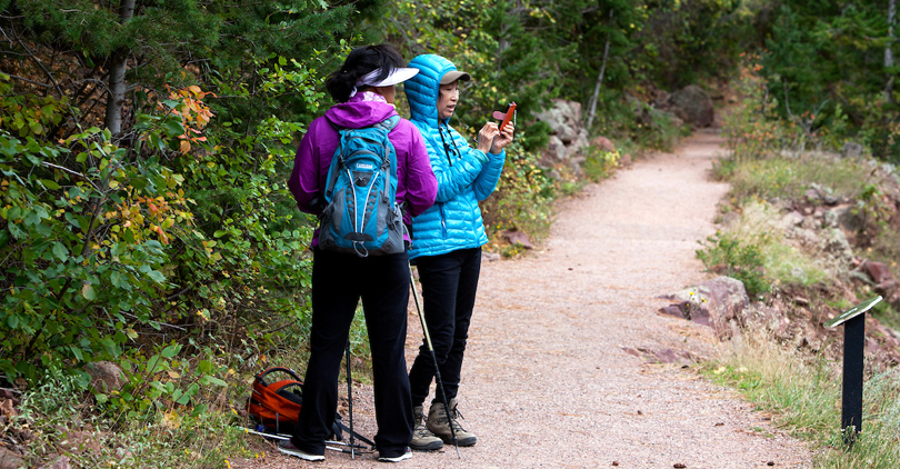 Two women hikers pause at a trailhead in Eldorado State Park.