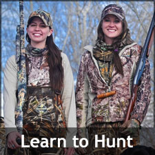 Two smiling young women in hunting gear