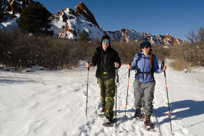 two people on snowshoes with glasses and hats