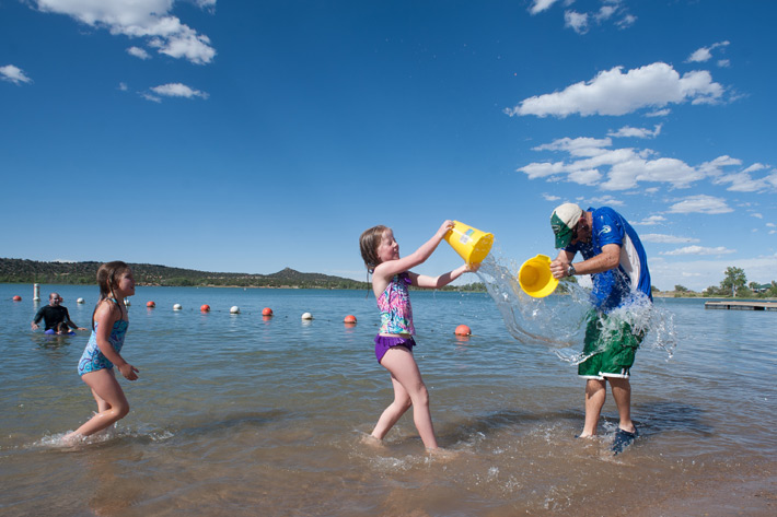 a family splashes in the lake with buckets