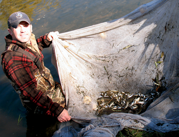 Aquatic research scientist Ryan Fitzpatrick with fishing net.